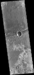 The linear depression in the center of this image captured by NASA's Mars Odyssey spacecraft is a graben - a fault bounded block of material. The graben crosses the crater and ejecta in the middle of the image.