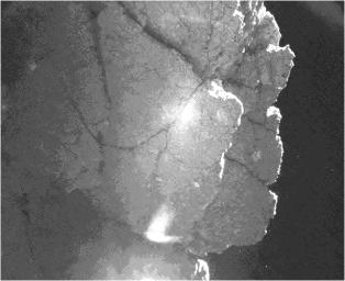 From the location where it came to rest after bounces, the Philae lander of the European Space Agency's Rosetta mission captured this view of a cliff on the nucleus of comet 67P/Churyumov-Gerasimenko. The feature is called 'Perihelion Cliff'.