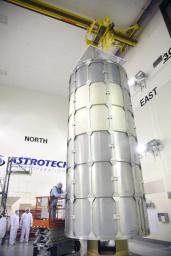 In the Astrotech payload processing facility on Vandenberg Air Force Base in California, technicians secure a transportation canister around NASA's Soil Moisture Active Passive (SMAP) spacecraft for its move to the launch pad.