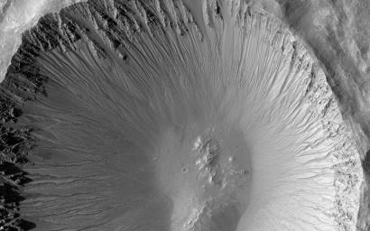 The central portion of this image is dominated by a sharp-rimmed crater that is roughly 5 kilometers in diameter. On its slopes, gullies show young (geologically recent) headward erosion, which is the lengthening of the gully in the upslope direction.