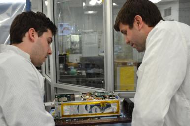 Engineers for NASA's MarCO technology demonstration inspect one of the two MarCO CubeSats. Cody Colley, MarCO integration and test deputy, left, and Andy Klesh, MarCO chief engineer, are on the team at NASA's Jet Propulsion Laboratory, Pasadena, CA.