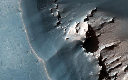 This image, captured by NASA's Mars Reconnaissance Orbiter spacecraft, shows the western side of an elongated pit depression in eastern Noctis Labyrinthus. Along the pit's upper wall is a light-toned layered deposit.