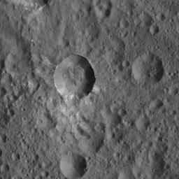This view from NASA's Dawn spacecraft shows an unnamed Cerean crater that is surrounded by a smooth blanket of ejecta, including bright material. Both the area around the crater and its floor are peppered with giant boulders.