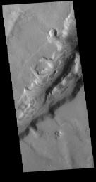 Nili Fossae is a large band of parallel graben located to the northeast of Syrtis Major. The graben in this image from NASA's 2001 Mars Odyssey spacecraft were formed by tectonic activity.