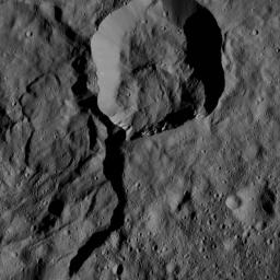 NASA's Dawn spacecraft views a crater at top center that touches the rim of Messor Crater (25 miles, 40 kilometers), shown at left.