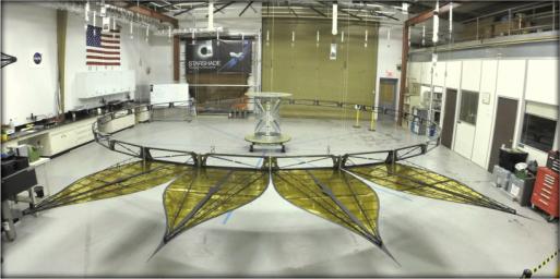 This image shows a deployed half-scale starshade with four petals at NASA's JPL. On a starshade ready for launch, the thermal gold foil will only cover the side of the petals facing away from the telescope.