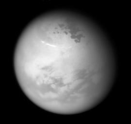 NASA's Cassini spacecraft sees bright methane clouds drifting in the summer skies of Saturn's moon Titan, along with dark hydrocarbon lakes and seas clustered around the north pole.