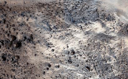 This image from NASA's Mars Reconnaissance Orbiter shows a fresh well-preserved landslide scarp and rocky deposit off the edge of a streamlined mesa in Simud Valles, a giant outflow channel carved by ancient floods.