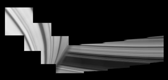 Saturn looms in the foreground of this mosaic of NASA's Cassini images, taken by the spacecraft on May 28, 2017. The planet is adorned by ring shadows. The icy rings emerge from behind the planet. Cassini ended its mission on Sept. 15, 2017.