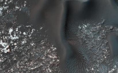 On the west (left) side of this image from NASA's Mars Reconnaissance Orbiter, fairly textbook-looking barchan sand dunes sit atop the bedrock. In between these opposing barchan dunes are star dunes.