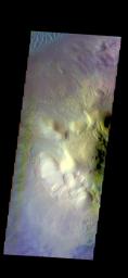 This false color image of Moreux Crater captured by NASA's 2001 Mars Odyssey spacecraft shows the highest elevations of the central peak, as well as the nearby sand dunes.