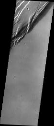 This image from NASA's 2001 Mars Odyssey spacecraft shows a portion of the western wall of the caldera, revealing the steep walls and linear features associated with the collapse that formed the caldera.