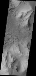 In this image of Tithonium Chasma from NASA's 2001 Mars Odyssey spacecraft both sides of the chasma are visible. This narrow and deep part of the chasma exist both large, chaotic block landslide deposits with smaller lobate shaped landslide deposits.