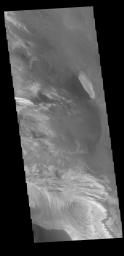 This image from NASA's 2001 Mars Odyssey spacecraft shows part of the interior of Candor Chasma. At the bottom of the frame is a bright feature formed by layers of material deposited in the canyon after it formed.