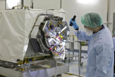 A technician inspects NASA's ECOSTRESS instrument in a clean room at Kennedy Space Center in Florida. ECOSTRESS measures the temperature of plants, which shows how they are regulating their water use in response to heat stress.