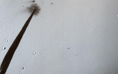 This image from NASA's Mars Reconnaissance Orbiter captured an impact crater that triggered a slope streak. When the meteoroid hit the surface and exploded to make the crater, it also destabilized the slope and initiated this avalanche.