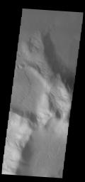 This image from NASA's Mars Odyssey shows an isolated mountain east of Hellas Planitia. Erosion is moving material down hill towards the lower elevations.