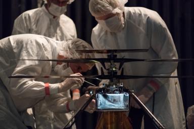 Members of NASA's Mars Helicopter team attach a thermal film enclosure to the fuselage of the flight model. The image was taken on Feb. 1, 2019.