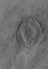 NASA's Mars Global Surveyor shows a circular feature on the martian northern plains. It was once a crater formed by meteoritic impact. It was completely filled and buried by and within layered material.
