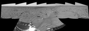 NASA's Mars Exploration Rover Spirit finished a drive and shows 'Bonneville' crater and the rocky plains surrounding it. The rover's solar panels are visible in the foreground, and the to right, the Columbia Hills complex. 