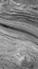 NASA's Mars Global Surveyor shows dozens of light- and a few dark-toned sedimentary rock layers exposed by faulting and erosion in western Candor Chasma, part of the vast Valles Marineris trough system on Mars.