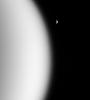 During a recent flyby of Titan, NASA's Cassini spacecraft looked beyond the utterly overcast moon and spied clear, distant Rhea in the blackness.