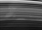 A broad and ghostly spoke drifts past under NASA's Cassini spacecraft's gaze. The spoke-forming region of the B ring displays faint longitudinal variations in brightness, from left to right.