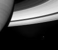 Beside the swirling face of Saturn is the small, icy attendant, Mimas as seen by NASA's Cassini spacecraft.