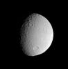 NASA's Cassini spacecraft surveys the battered surface of Saturn's icy moon Tethys. The great impact basin straddling the terminator is itself overprinted by many smaller impact sites.