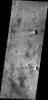 This image from NASA's Mars Odyssey spacecraft shows a portion of Syrtis Major Planum. There are several windstreaks with the classic dark rim/bright interior appearance.