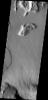 This image from NASA's Mars Odyssey shows a small portion of the northern escarpment of Olympus Mons. The semi-circular deposit on the left side of the frame is a large landslide deposit.