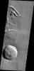 This image from NASA's Mars Odyssey shows part of the eastern flank of Ascraeus Mons, one of the large Tharsis Volcanoes. The circular pits all aligned in a row mark the collapse of the roof of a lava tube.