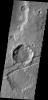 The downdropped block of surface seen in this image captured by NASA's 2001 Mars Odyssey spacecraft is called a graben. The graben is younger than the crater, since the crater is cut by the graben.