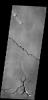 This image from NASA's 2001 Mars Odyssey spacecraft shows a small region between Olympus Mons and Sulci Gordii. There are lava flows, tectonic depressions and channels visible in the image. All the features are related to the volcanism.