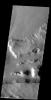 The linear wall at the bottom of this image from NASA's 2001 Mars Odyssey spacecraft is a fault. The linear depression caused by faulting is part of a long depression called Mangala Fossae.