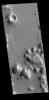 This image captured by NASA's 2001 Mars Odyssey spacecraft shows dark slope streaks on several small mesas in Amazonis Planitia.