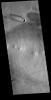 The 'tail' behind the crater at the top of this image from NASA's 2001 Mars Odyssey spacecraft is called a windstreak. This feature is formed by winds blowing over/in and around the crater.
