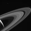 NASA's Cassini gazes across the icy rings of Saturn toward the icy moon Tethys, whose night side is illuminated by Saturnshine, or sunlight reflected by the planet.
