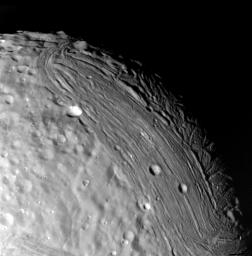 Miranda reveals a complex geologic history in this view, acquired by NASA's Voyager 2 on Jan. 24, 1986, around its close approach to the Uranian moon. At least three terrain types of different age and geologic style are evident.