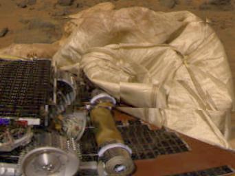 This image from the Imager for Mars Pathfinder (IMP) camera shows the rear part of NASA's Sojourner rover, the rolled-up rear ramp, and portions of the partially deflated airbags.