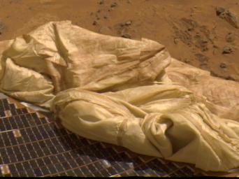 Details of one of Pathfinder's deflated airbags adjacent to a lander petal are prominent in this image, taken by NASA's Imager for Mars Pathfinder (IMP). The blue tiles on top of the petal are solar cells that are used to give power to the lander.