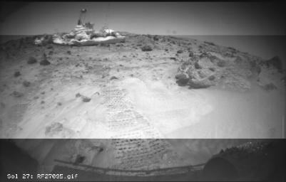 This image from NASA's Sojourner rover's right front camera was taken on Sol 27. The Pathfinder lander is seen at middle left. The large rock at right, nicknamed 'Squash,' exhibits a diversity of textures. Sol 1 began on July 4, 1997.