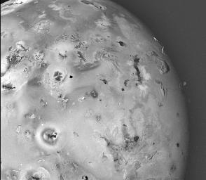 This is a topographic map of Jupiter's moon Io acquired by NASA's Galileo spacecraft in 2001, revealing rugged mountains several miles high, layered materials forming plateaus, and many irregular depressions called volcanic calderas.