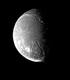 NASA's Voyager 2 took this image on January 24, 1986, showing Ariel's surface densely pitted with craters. Numerous valleys and fault scarps crisscross the highly pitted terrain.