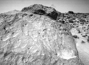 A close-up view of the rock 'Moe' in the 'Rock Garden' at the Pathfinder landing site. 'Moe' is a meter-size boulder that, as seen by NASA's Sojourner, has a relatively smooth yet pitted texture upon close examination. Sol 1 began on July 4, 1997.