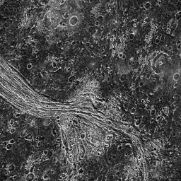 This image from NASA's Galileo spacecraft shows a highly fractured lane of grooved terrain, Lagash Sulcus, which runs through an area of heavily cratered dark terrain within Marius Regio on Jupiter's moon Ganymede.