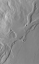 NASA's Mars Global Surveyor shows the volcanic Tharsis region, including these valleys and associated lava flows on the plains southeast of Olympus Mons. Lava flows are visible, but meandering valleys with streamlined 'islands' dominate the scene.