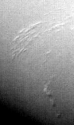 This image of Neptune's south polar region was obtained by NASA's Voyager on Aug. 23, 1989. The smallest cloud features are 45 kilometers (28 miles) in diameter. The image shows the discovery of shadows in Neptune's atmosphere, shadows cast onto a deep cl