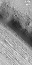 NASA's Mars Global Surveyor shows valley floors in the middle latitudes of Mars, particularly in the 'fretted terrain' of northern Arabia Terra which have curious grooved and pitted surfaces.