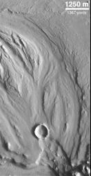 NASA's Mars Global Surveyor shows a fluid-scoured surface in the Hrad Vallis system, located northwest of Elysium Mons on Mars. The fluid is presumed to have been water.